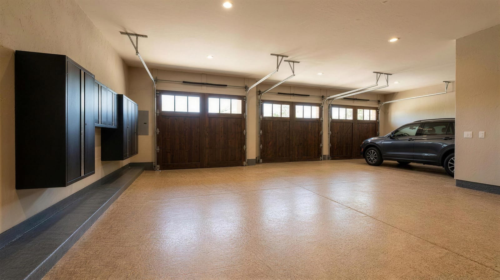 Tan and brown flake polyaspartic floor coating in a three-car garage