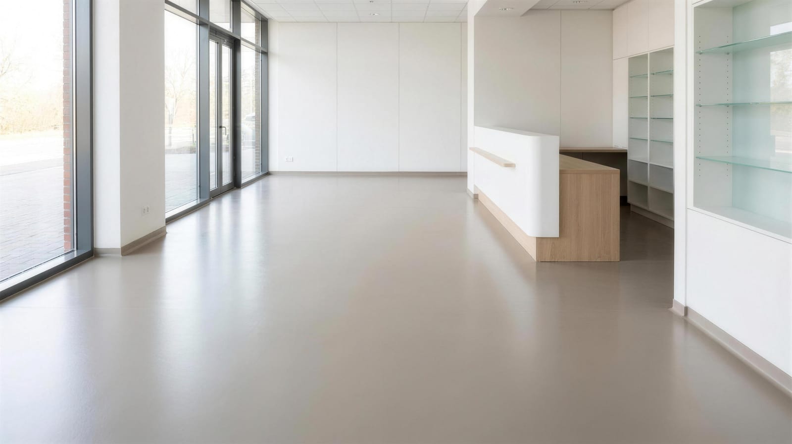 Warm gray solid-color satin polyaspartic floor in a bright office reception area