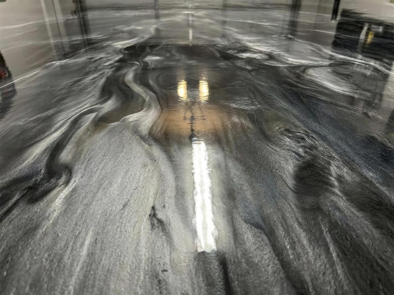 Close-up of a metallic epoxy floor with pearlescent silver and charcoal swirls
